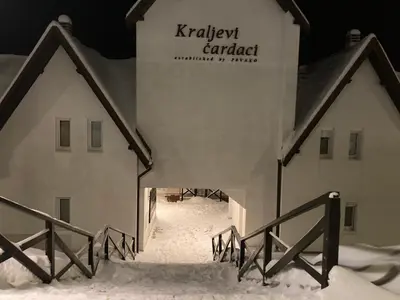 a building with a sign on it in the snow at Apartman ČAR 19 in Kopaonik