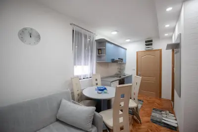 a living room with a couch and a table and a kitchen at Apartman Kopaonik Despotovic in Kopaonik