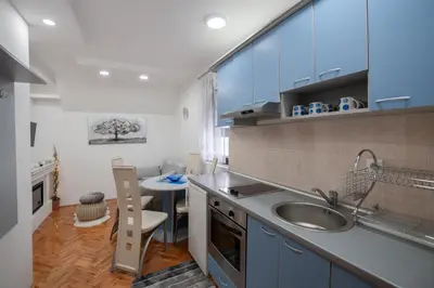 a small kitchen with a sink and a table at Apartman Kopaonik Despotovic in Kopaonik