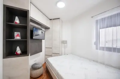 a small bedroom with a bed and a window at Apartman Kopaonik Despotovic in Kopaonik