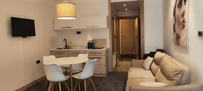 a living room with a couch and a table and a kitchen at Snow White apartments in Kopaonik