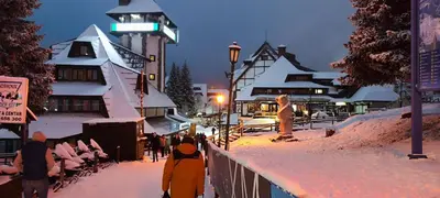 a group of people standing in the snow near a building at Snow White apartments in Kopaonik