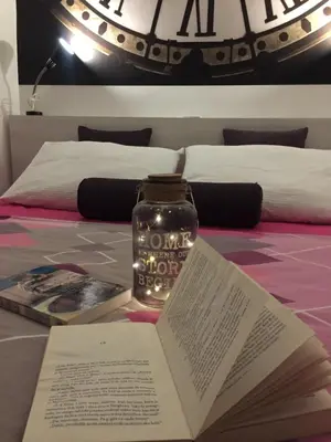 an open book on a bed with a jar on it at MONI Luxury Apartments in Kopaonik