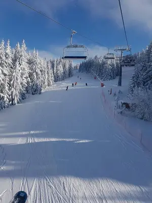 a snow covered ski slope with a ski lift at MONI Luxury Apartments in Kopaonik
