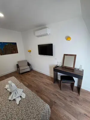 a room with a desk and a bed and a mirror at Hotel Sax Balkan in Dimitrovgrad
