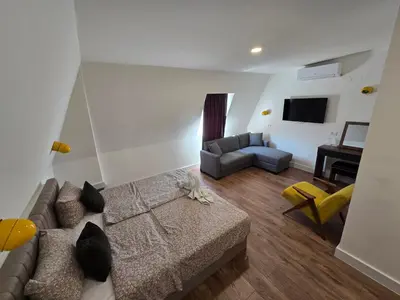a living room with a couch and a chair at Hotel Sax Balkan in Dimitrovgrad