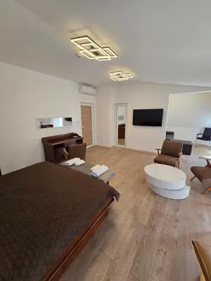 a bedroom with a bed and a living room at Hotel Sax Balkan in Dimitrovgrad