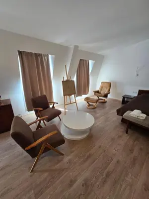 a living room with chairs and a couch and a table at Hotel Sax Balkan in Dimitrovgrad