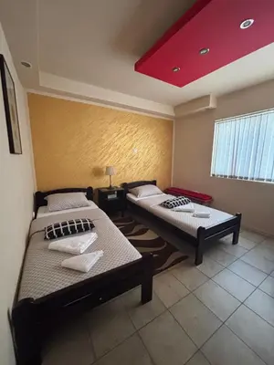 two beds in a room with a red ceiling at Dody Apartmani in Leskovac