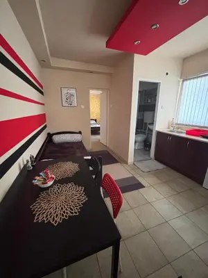 a room with a table and a dining room at Dody Apartmani in Leskovac