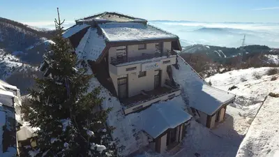 a building on top of a snow covered mountain at Dvori Apartments in Kopaonik