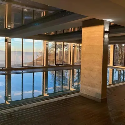a room with a large window with a view of the water at Modern Lux Apartment H8 at Milmari Resort in Kopaonik