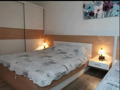 a bedroom with a large white bed with two lamps at Modern Lux Apartment H8 at Milmari Resort in Kopaonik
