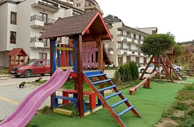 a playground with a slide and a play structure at Modern Lux Apartment H8 at Milmari Resort in Kopaonik