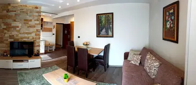 a living room with a couch and a dining room at Modern Lux Apartment H8 at Milmari Resort in Kopaonik