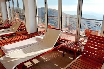 a balcony with chairs and a bed on a ship at Modern Lux Apartment H8 at Milmari Resort in Kopaonik