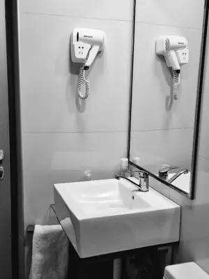 a bathroom with a sink and a mirror and a phone at Blue New Yorker in Niš