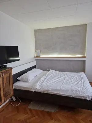 a bedroom with a bed and a flat screen tv at Blue New Yorker in Niš