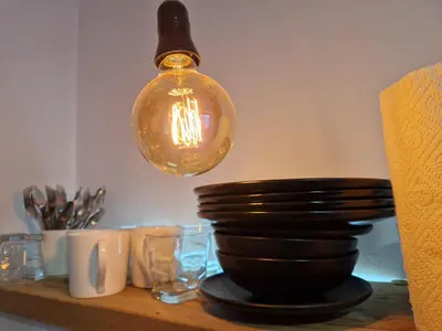 a light hanging over a table with plates and glasses at Blue New Yorker in Niš