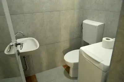 a bathroom with a toilet and a sink at Community Park Apartment in Niš