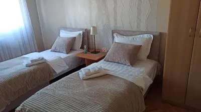 a hotel room with two beds and a table at Community Park Apartment in Niš