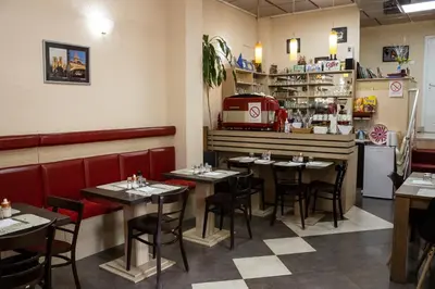 a dining room with tables and a counter in a restaurant at Bed and Breakfast Majesty in Niš
