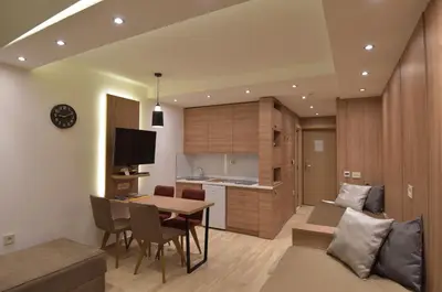 a kitchen and living room with a table and a couch at Apartmani Prime in Kopaonik