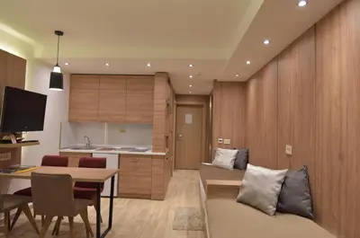 a kitchen and a living room with a table and chairs at Apartmani Prime in Kopaonik