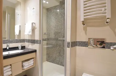 a bathroom with a glass shower and a sink at Apartmani Prime in Kopaonik