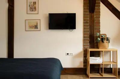 a bedroom with a bed and a flat screen tv on the wall at Apartment By the River in Niš