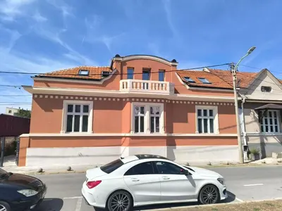 a white car parked in front of a house at Apartment By the River in Niš