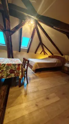 a attic room with two beds and a table at Apartment By the River in Niš