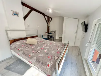 a bedroom with a bed with a comforter on it at Apartment By the River in Niš