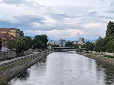 a river with a bridge in a city at Apartment By the River in Niš