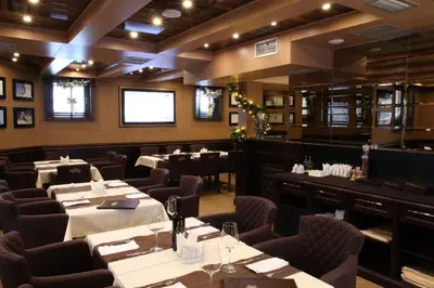 a restaurant with tables and chairs in a room at Apart Hotel Mamut in Kopaonik