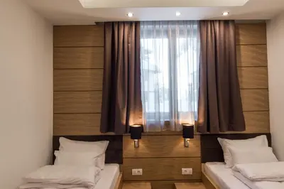 two beds in a room with a window at Apart Hotel Mamut in Kopaonik