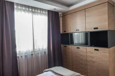 a bedroom with wooden cabinets and a large window at Apart Hotel Mamut in Kopaonik