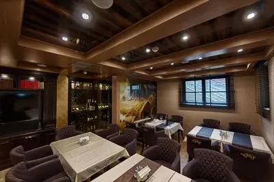 a restaurant with tables and chairs in a room at Apart Hotel Mamut in Kopaonik