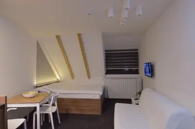 a small room with a bed and a table at Apartman Jelač Konaci in Kopaonik
