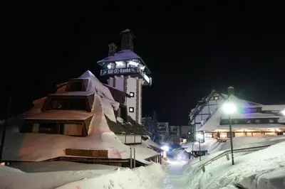 a building with a sign on it in the snow at Apartman Jelač Konaci in Kopaonik