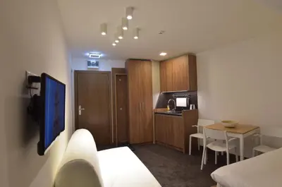 a room with a kitchen and a room with a bed and a table at Apartman Jelač Konaci in Kopaonik