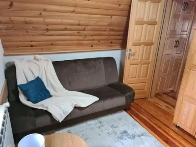 a leather couch with a blanket and a blue pillow at Dajoda free spa in Kopaonik