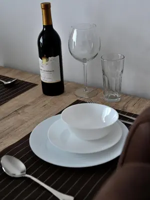 a bottle of wine and a plate and a glass at Chalet Vrhovi Kopaonika in Kopaonik