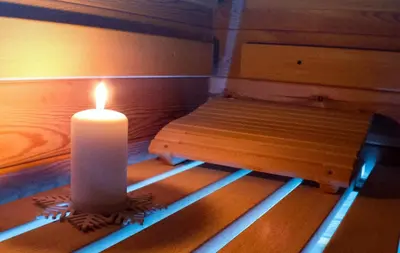 a candle sitting next to a wooden bench with a bench at Chalet Vrhovi Kopaonika in Kopaonik