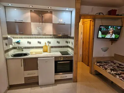 a kitchen with a sink and a tv on a wall at apartman na stazi in Kopaonik