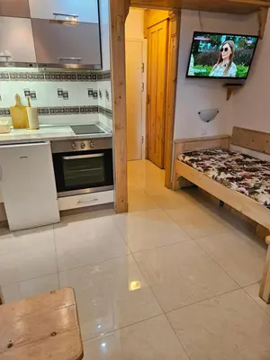 a kitchen with a tv on the wall and a counter at apartman na stazi in Kopaonik