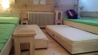 a room with two beds and a table and a backpack at apartman na stazi in Kopaonik