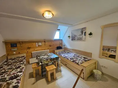 a room with two beds and a table in it at apartman na stazi in Kopaonik