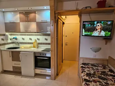 a kitchen with a flat screen tv on the wall at apartman na stazi in Kopaonik