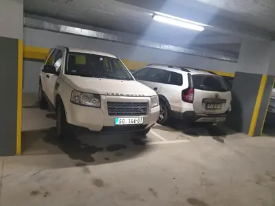 two white cars parked in a parking garage at Ebra Kraljevi Čardaci Kopaonik in Kopaonik